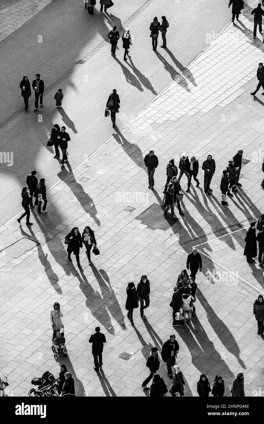 people walking at the street with long shadows Stock Photo