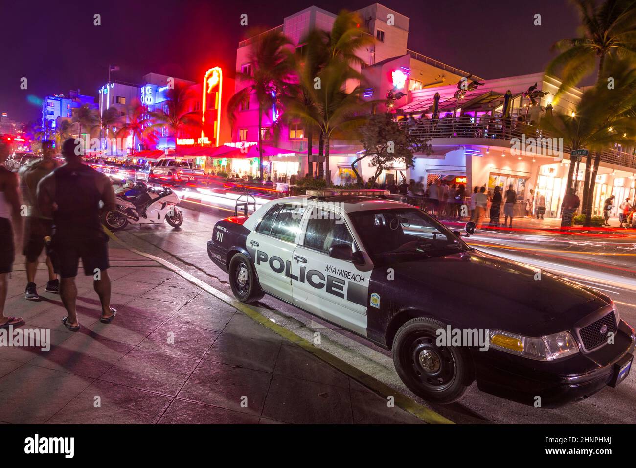 police car parks at the Ocean Drive along South Beach Miami in the historic Art Deco District with hotels, restaurant and bar by night Stock Photo