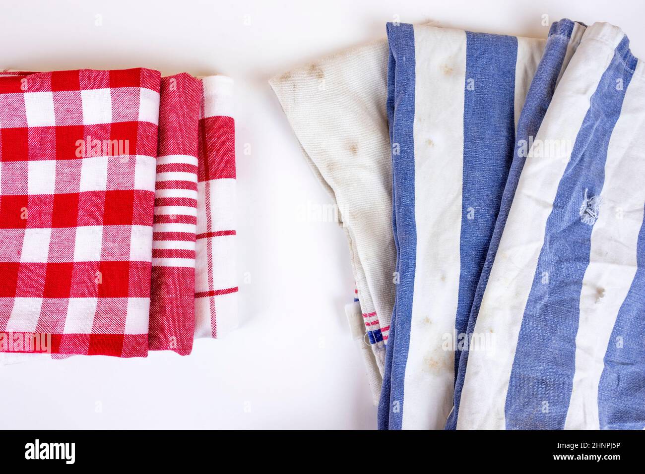 https://c8.alamy.com/comp/2HNPJ5P/three-new-red-checkered-kitchen-picnic-towels-folded-versus-old-dirty-torn-blue-cloth-towels-cleaning-and-regularly-changing-kitchen-rags-and-cloth-2HNPJ5P.jpg