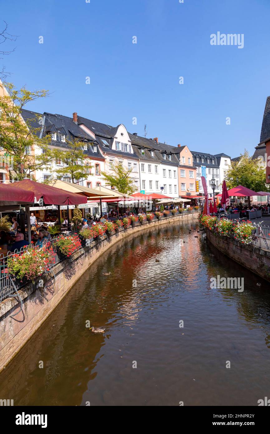 city center of Saarburg with creek and restaurants at the promenade. The creek is the source for the water mills at bottom of valley Stock Photo