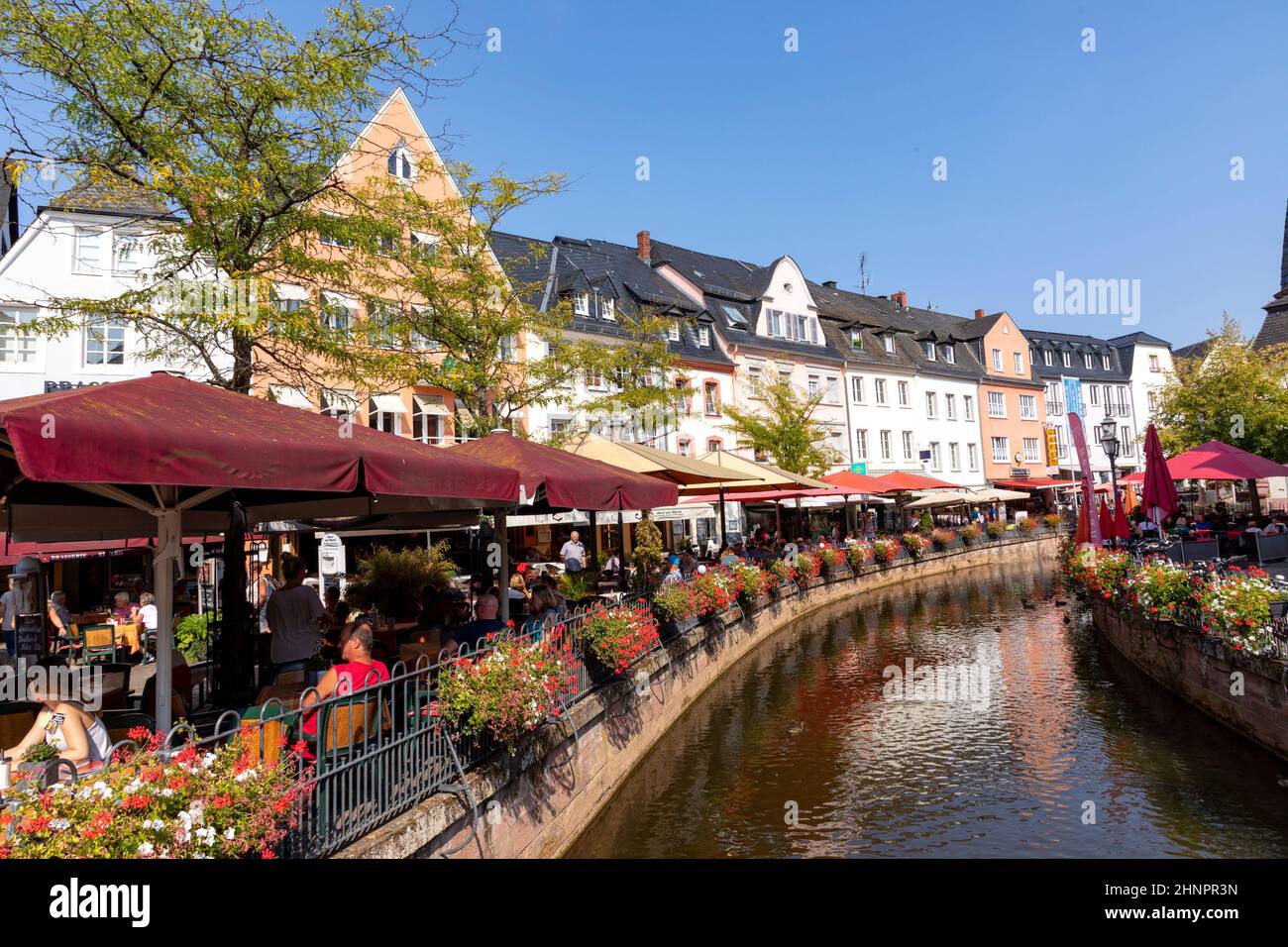 city center of Saarburg with creek and restaurants at the promenade. The creek is the source for the water mills at bottom of valley Stock Photo