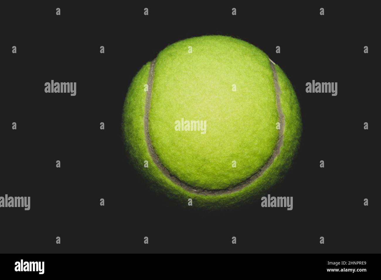 green tennis ball isolated on black background. sport equipment Stock