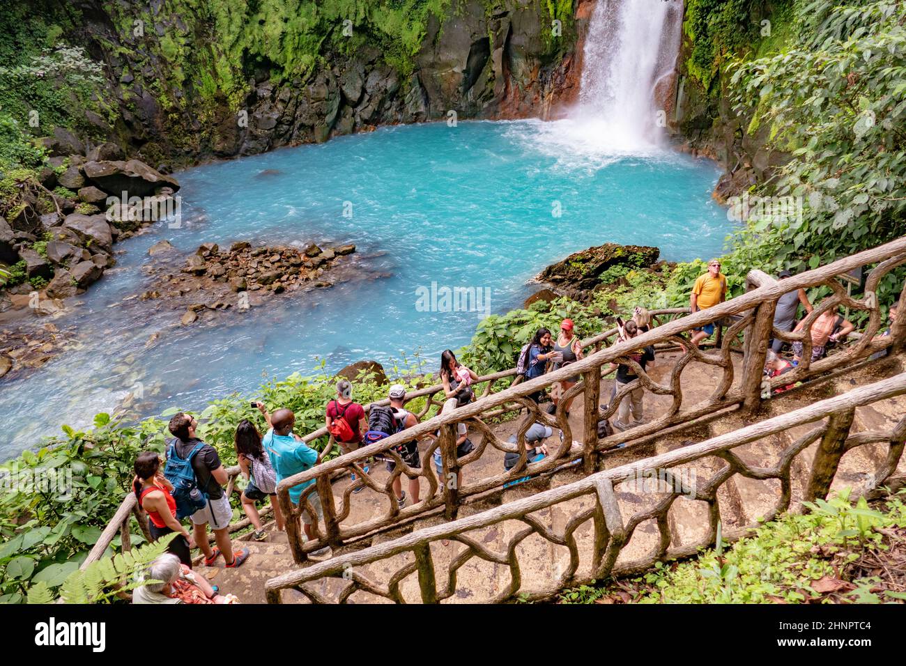 ourists watch from a platform the scenic waterfall in tenorio volcano national park Stock Photo