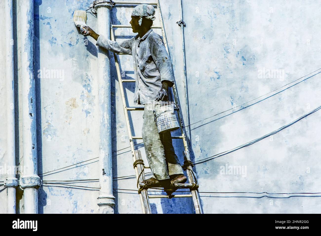 local painter paints the old wall in the typical blue color Stock Photo