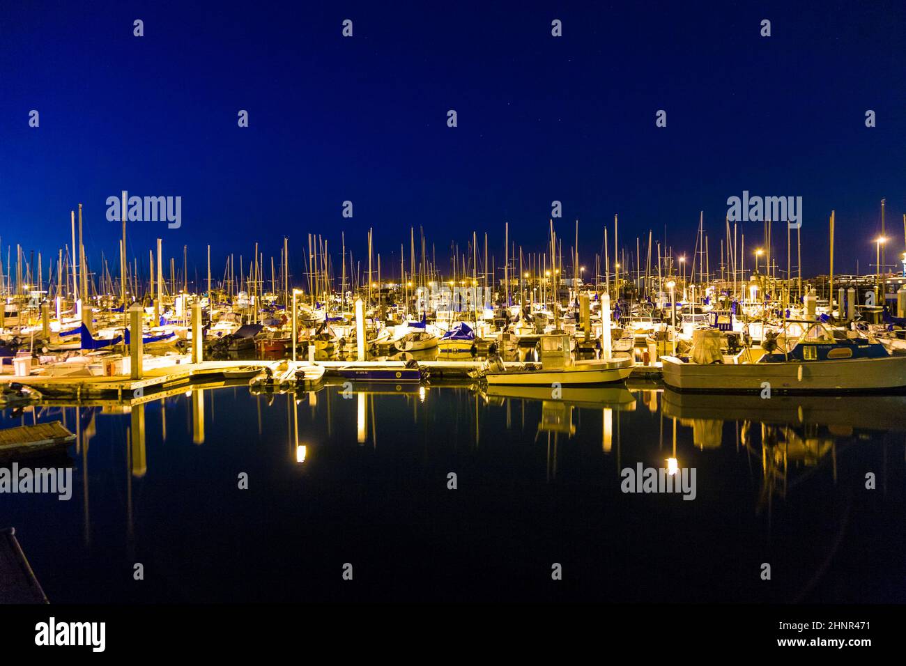 sailing boats in the windless Monterey harbor at the pier by night Stock Photo