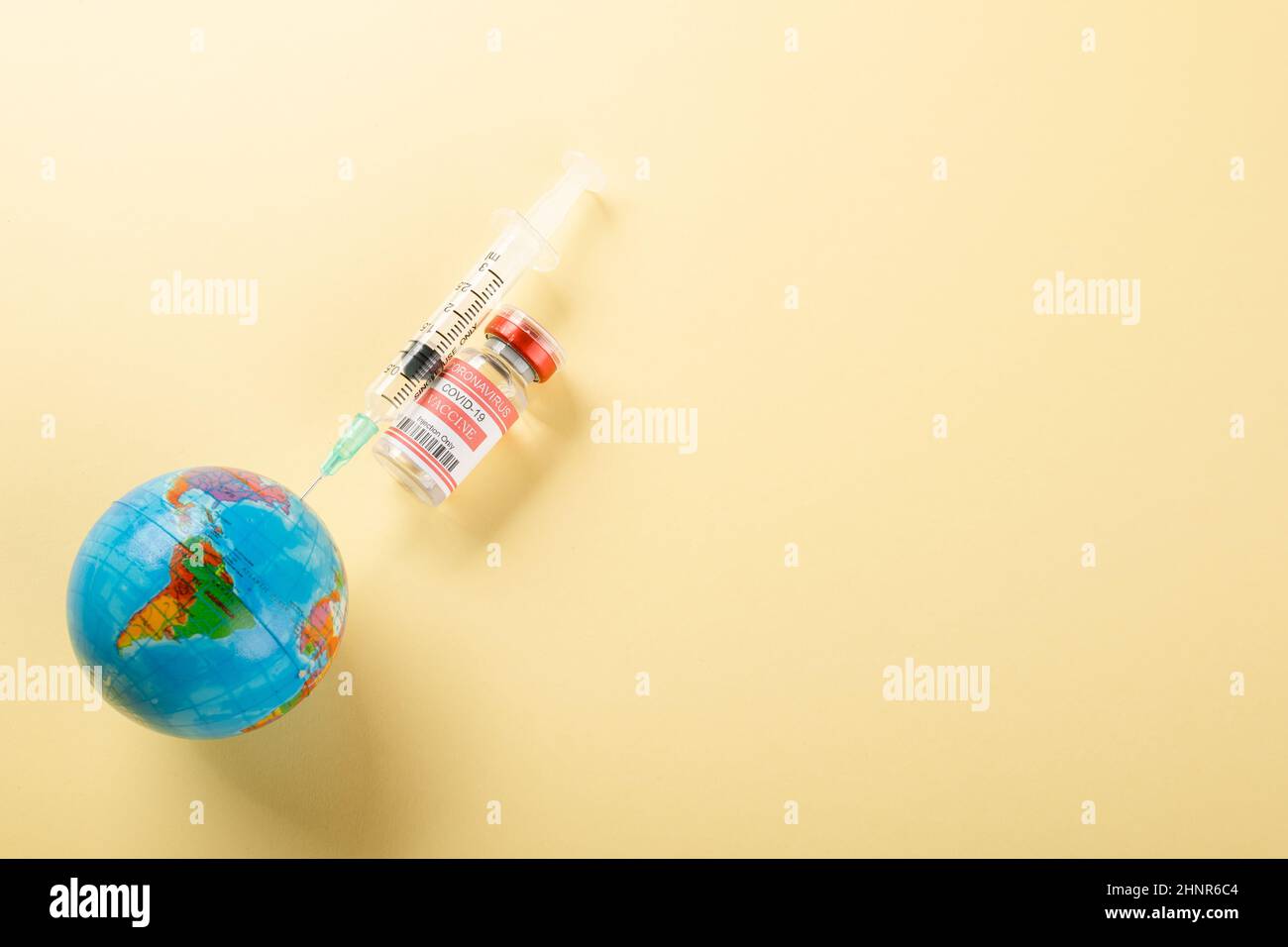 Vaccine vials bottles, syringes for vaccination against coronavirus and globe Stock Photo