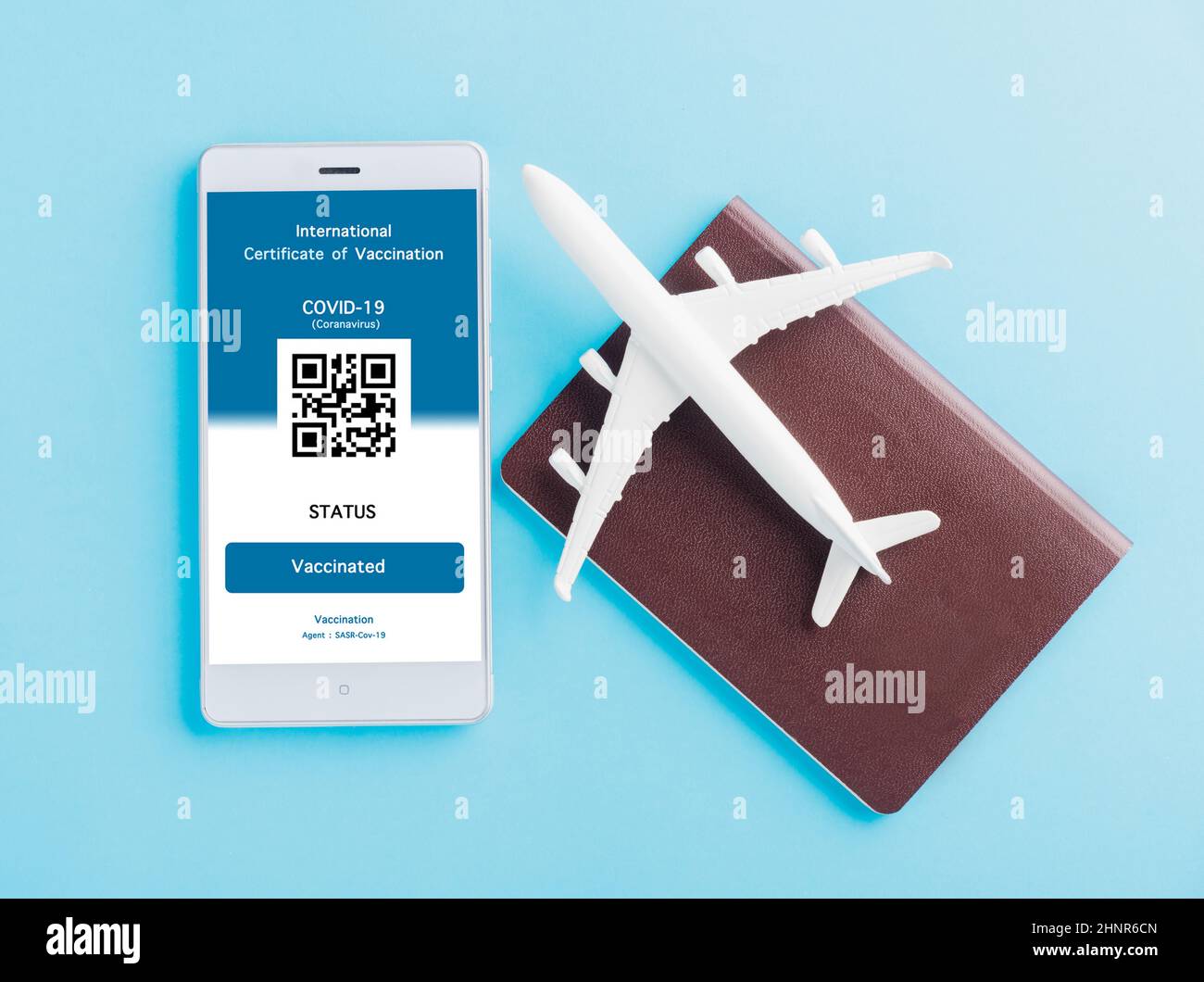 Model airplane, passport and immunity pass are arranged application on smartphone Stock Photo