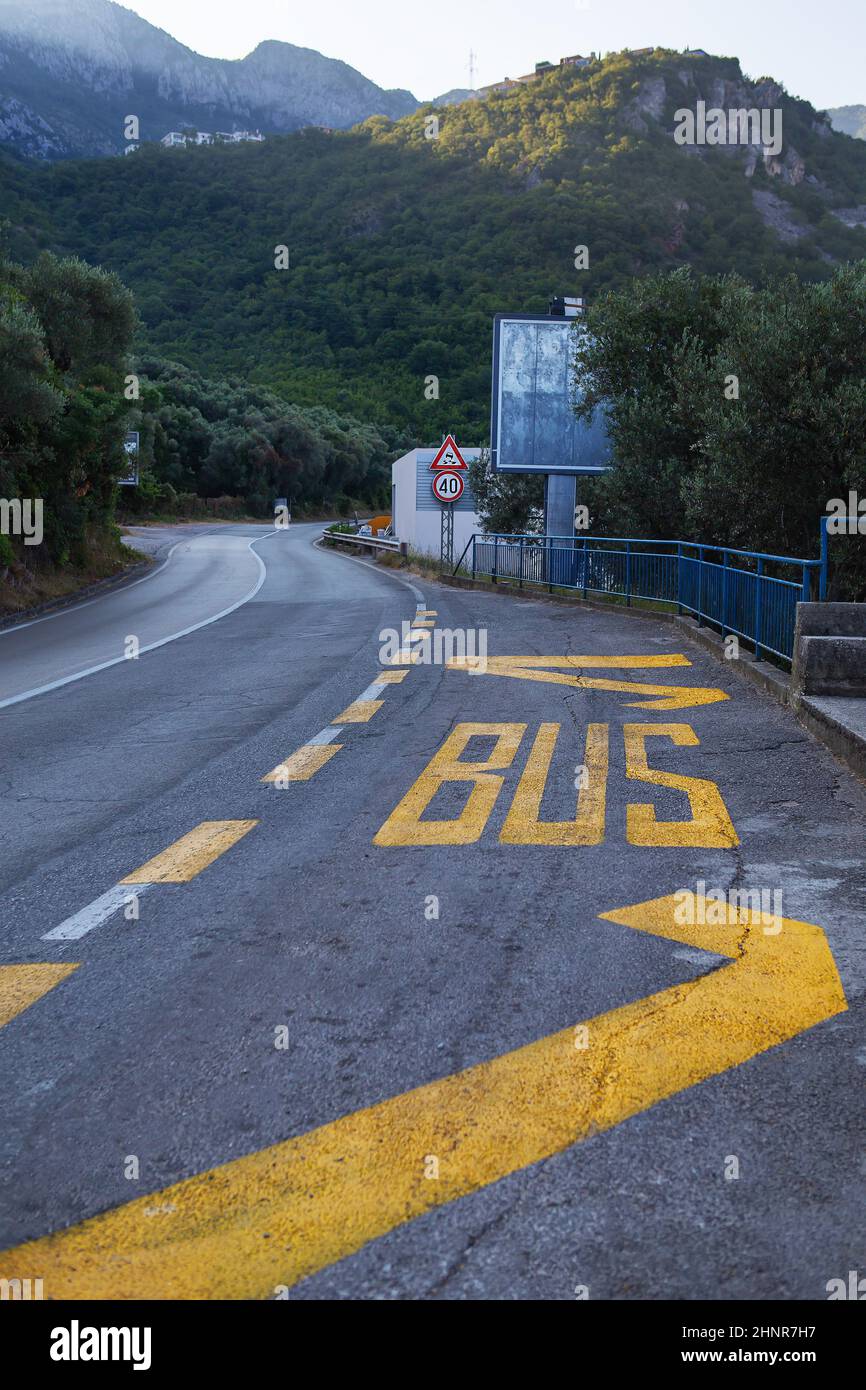 The inscription BUS in bright yellow paint, painted on the asphalt road Stock Photo