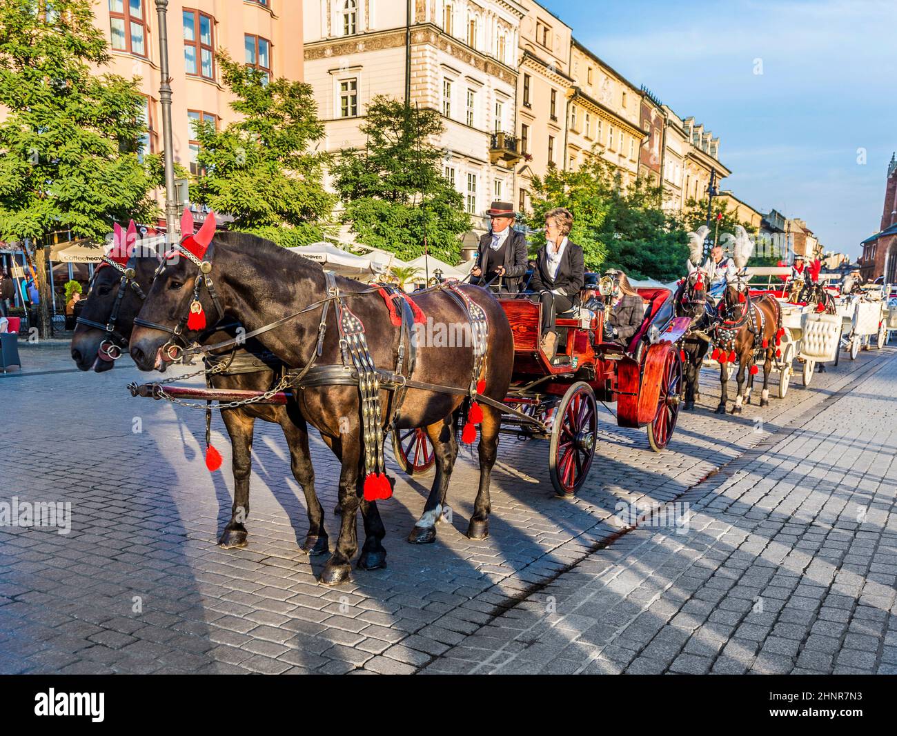 Horse carriages in front of Mariacki church on main square of Krakow Stock Photo