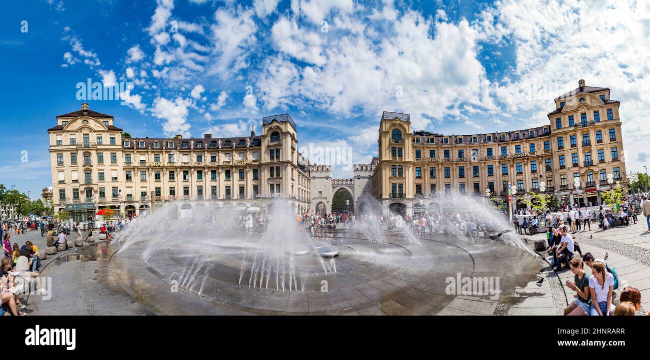 People walking along through the Karlstor gate in Munich and refresh at the fountain Stock Photo