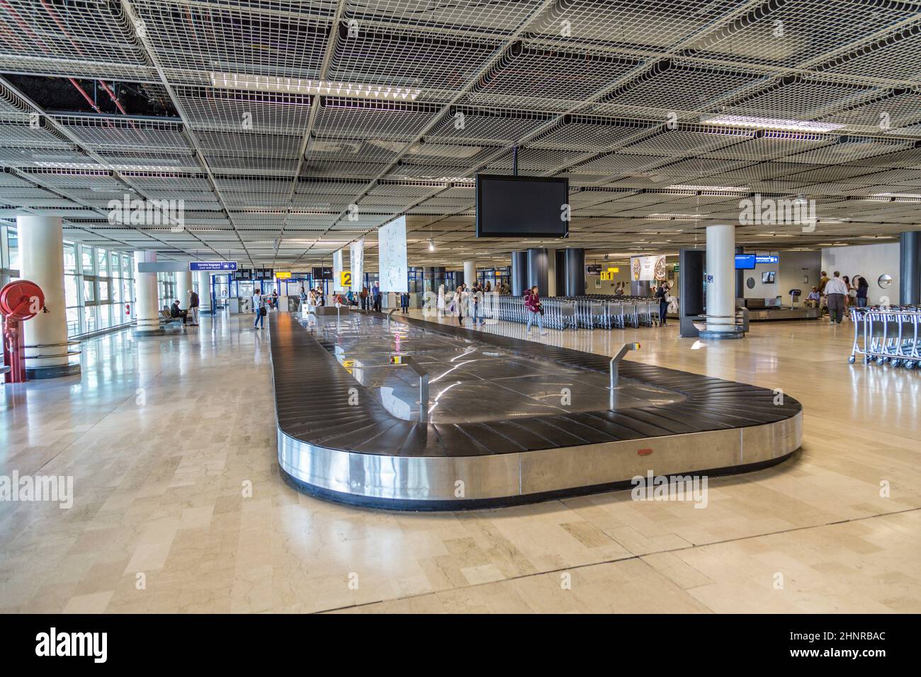 people at baggage belt inside the new terminal at airport of Marseilles, France Stock Photo