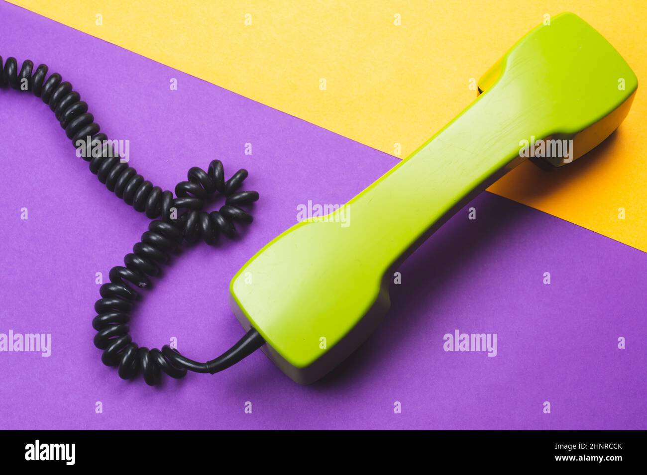 Vintage green telephone handset. phone receiver on color background