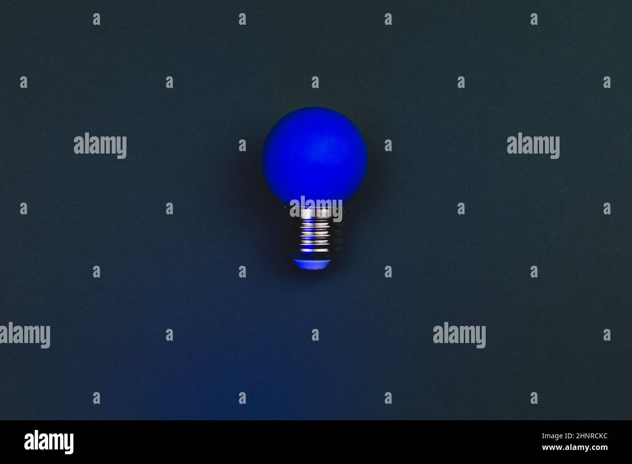 Blue light bulb on the dark background. single bulb with copy space ...