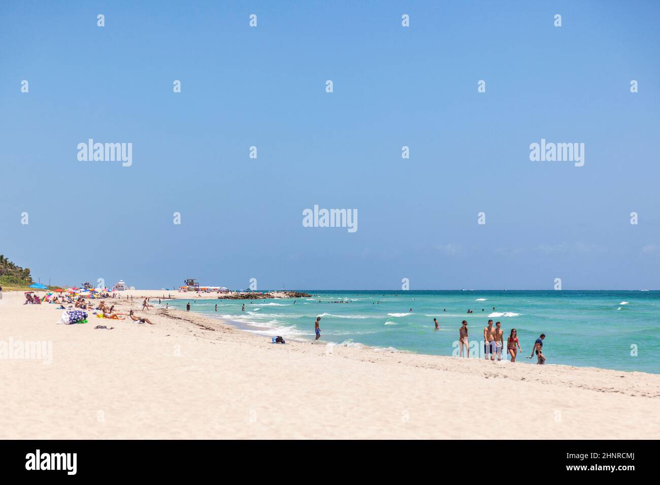 Tourists sunbath, swim and play on South Beach in Miami Beach, Florida Stock Photo