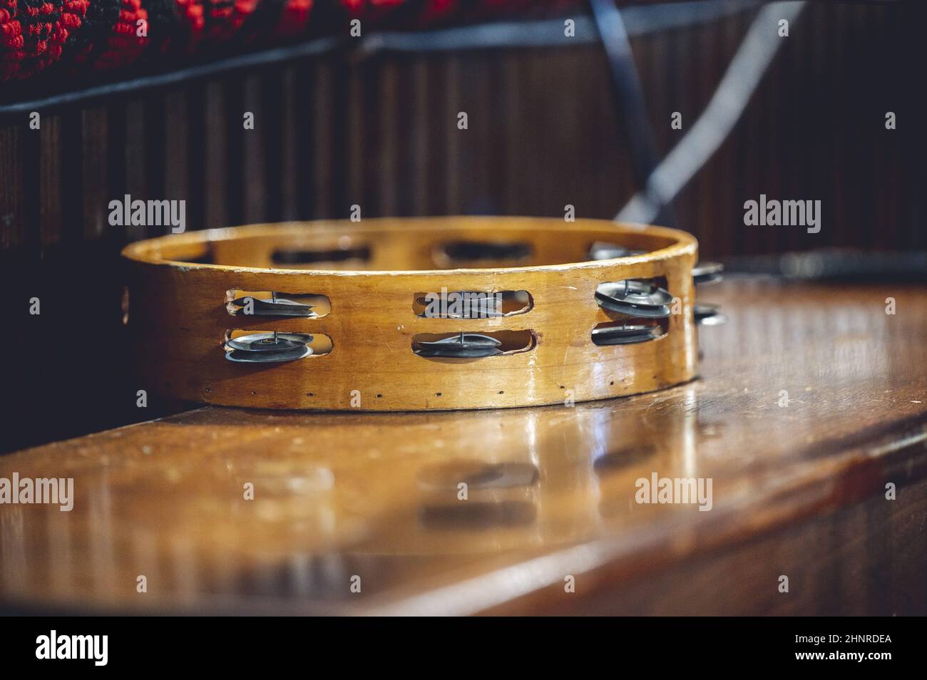 Closeup of a Tambourine instrument on a wooden table Stock Photo