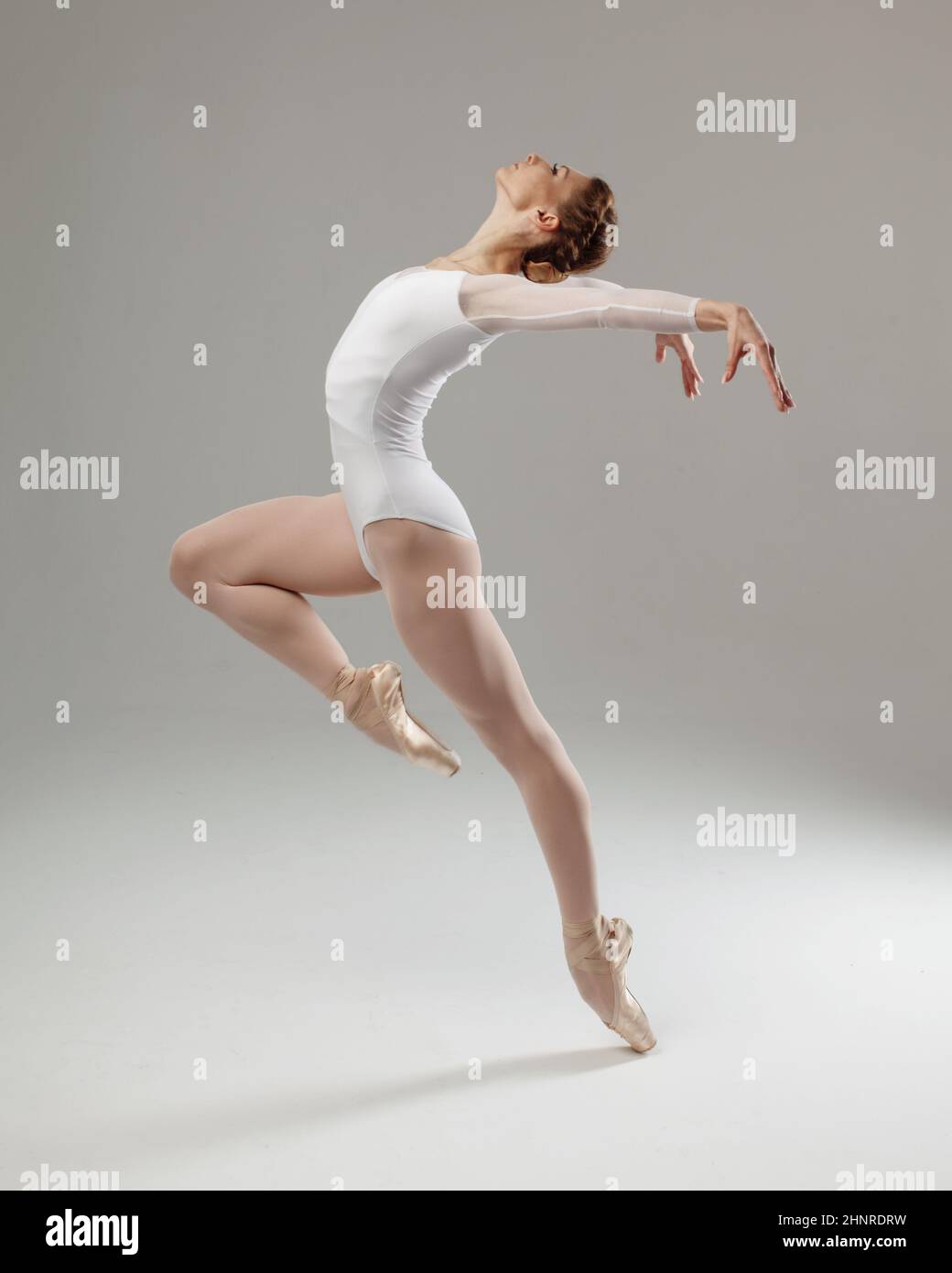 woman ballet dancer doing passe isolated on gray background Stock Photo Alamy