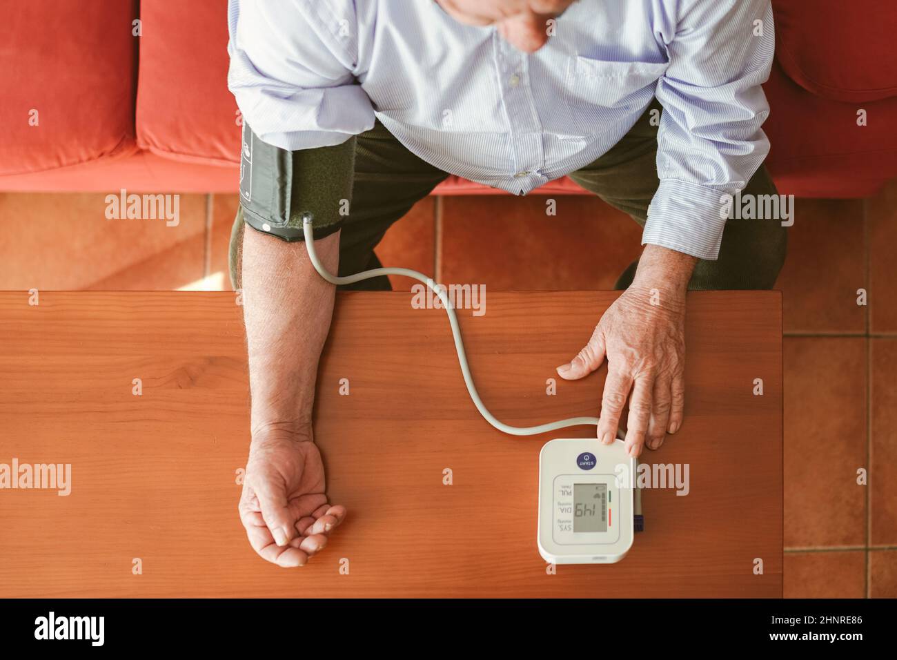 zenithal shot of an older man taking his blood pressure Stock Photo