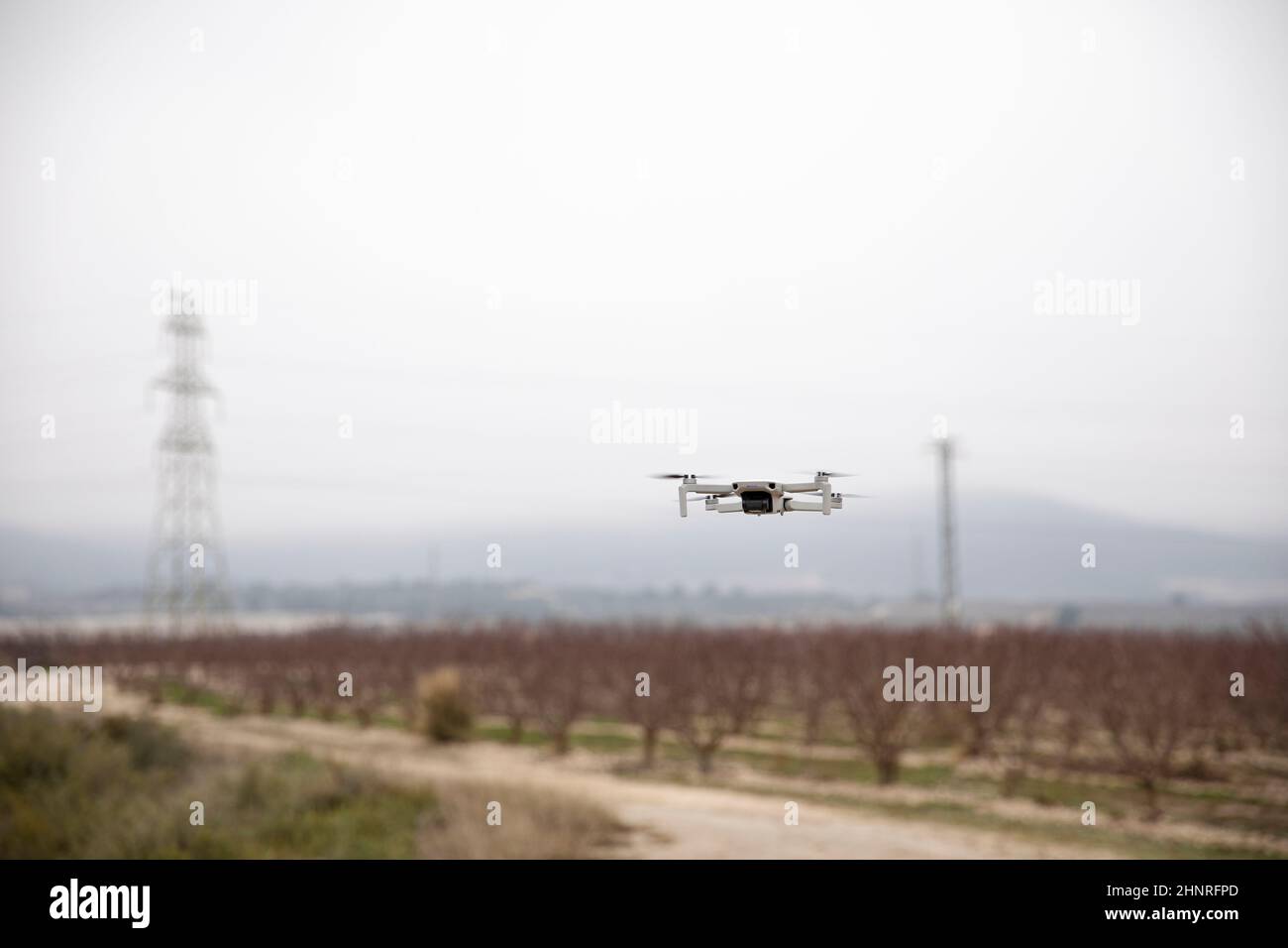 Modern drone flying freely in a field in nature Stock Photo