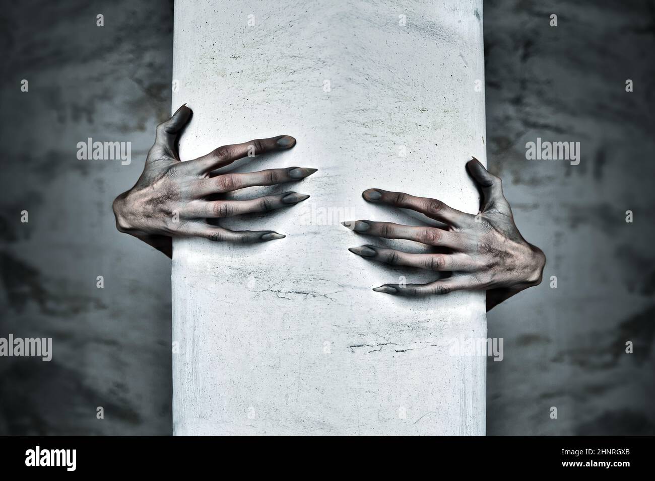 A Pair of Scary Hands Reach Out from Behind a COlumn Stock Photo