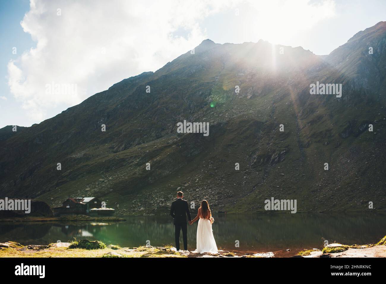 Rear view of a young married couple holding hands and looking at the ...