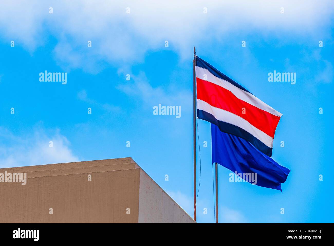 Flag of Costa Rica with old buildings behind Costa Rican flag blue