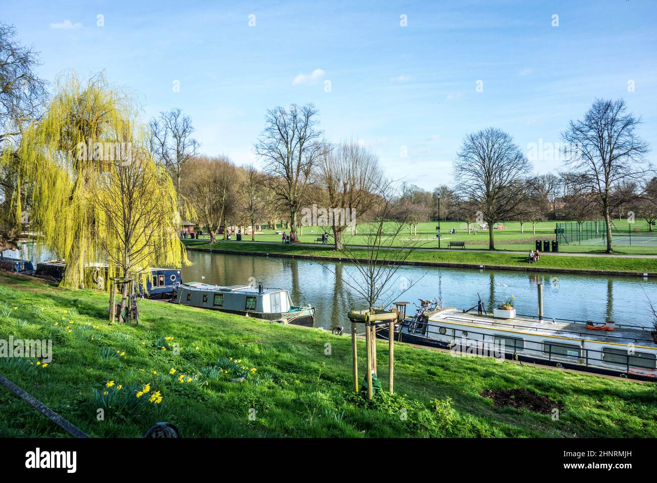people walking along river cam with house boats in Cambridge Stock Photo