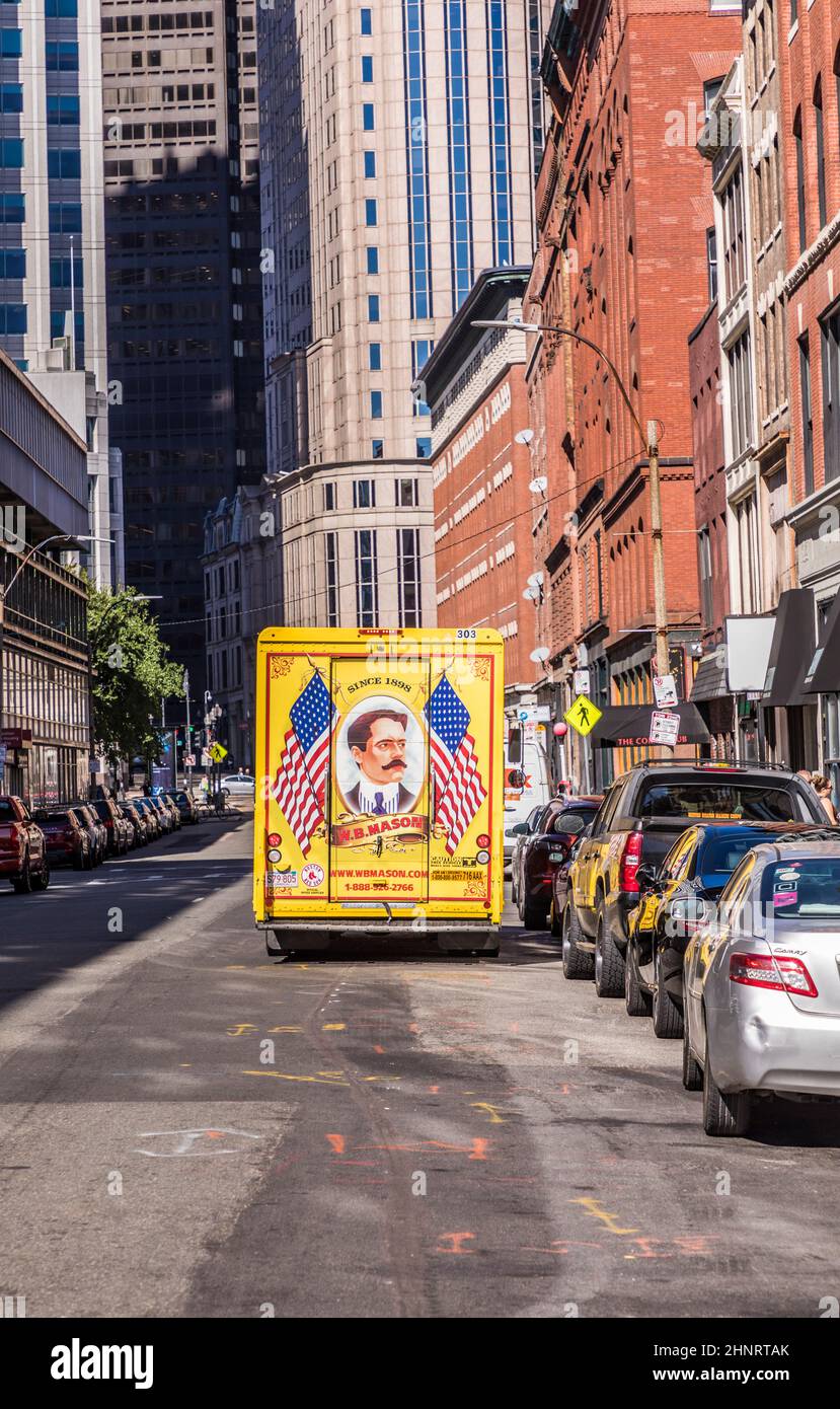 streetlife downtown Boston. The parcel service mason with its vintage painted yellow trucks deliveres parcels Stock Photo
