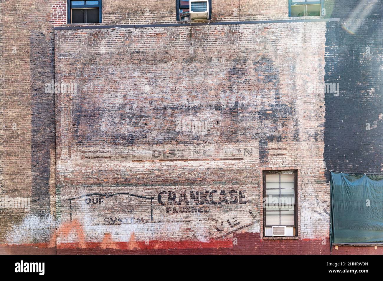old painted brick wall with old advertising of different brands in bad condition Stock Photo