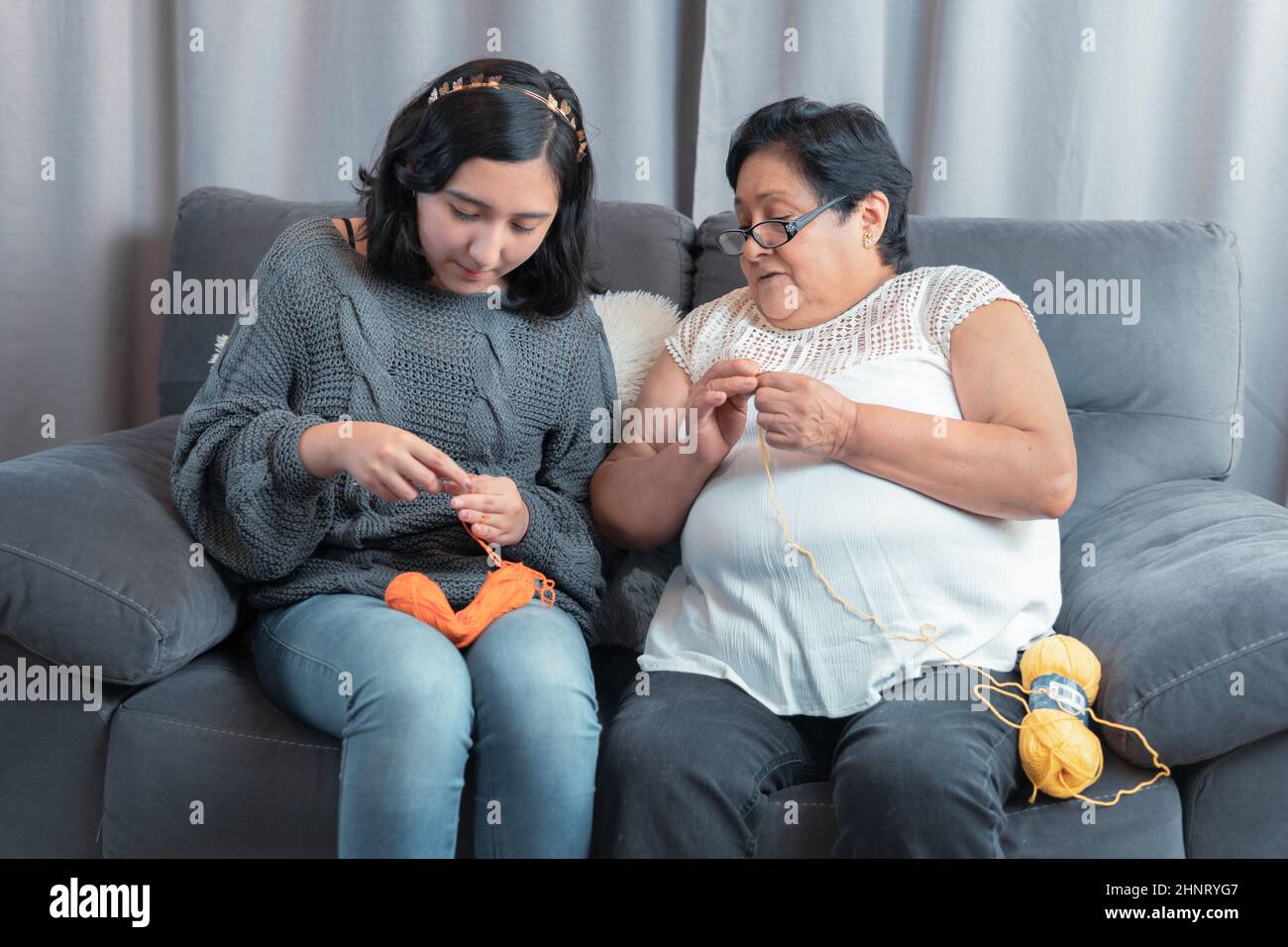 elderly woman 60 year old Latin grandmother knitting happily and