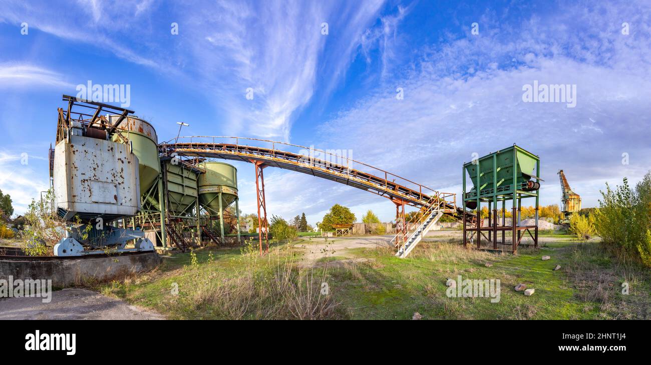 old industrial harbor with storage room, huge belt and lot of gravel positions in Trebur at river Rhine. Stock Photo