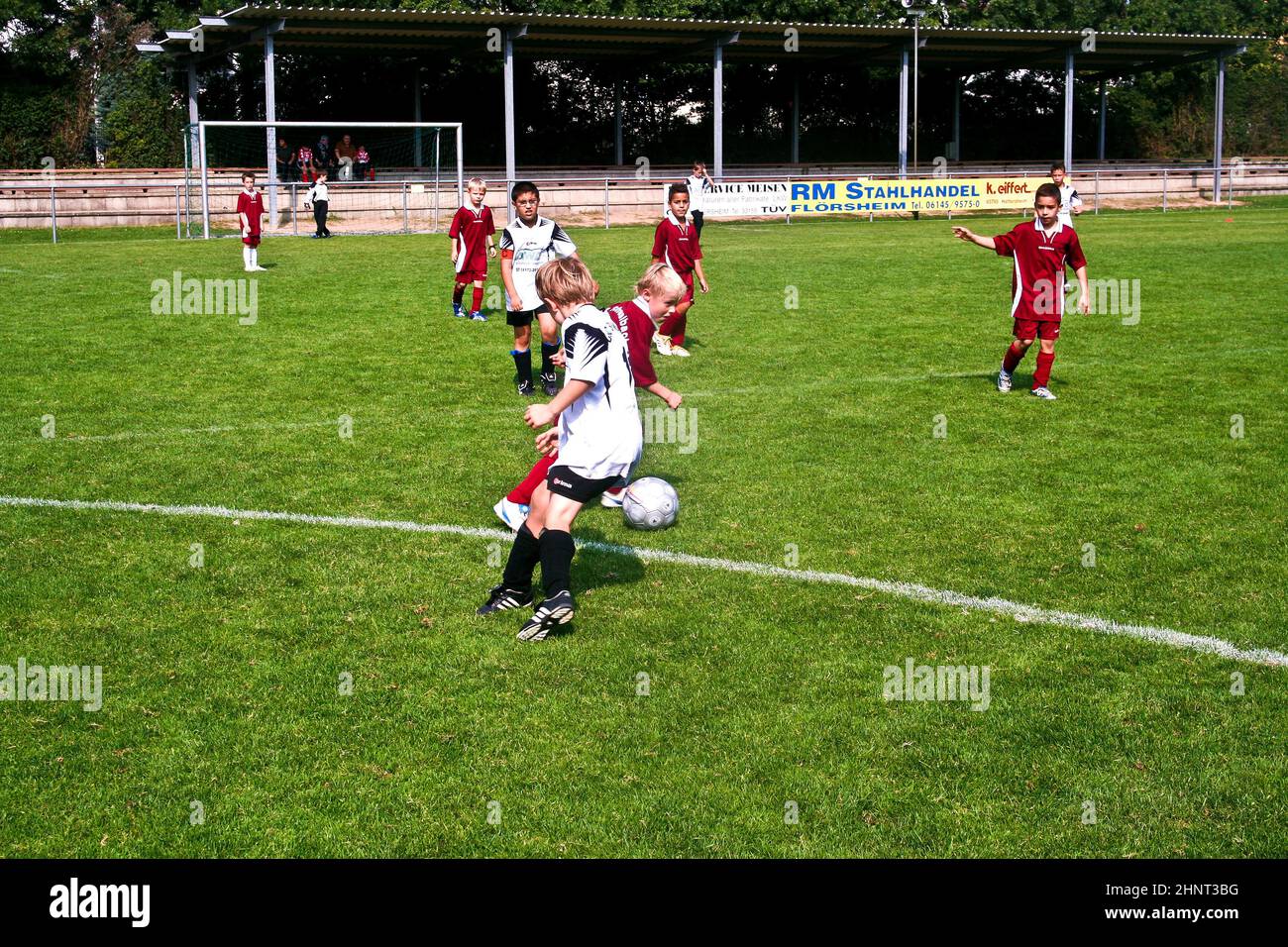 children playing soccer in summer in an outdoor grass arena Stock Photo