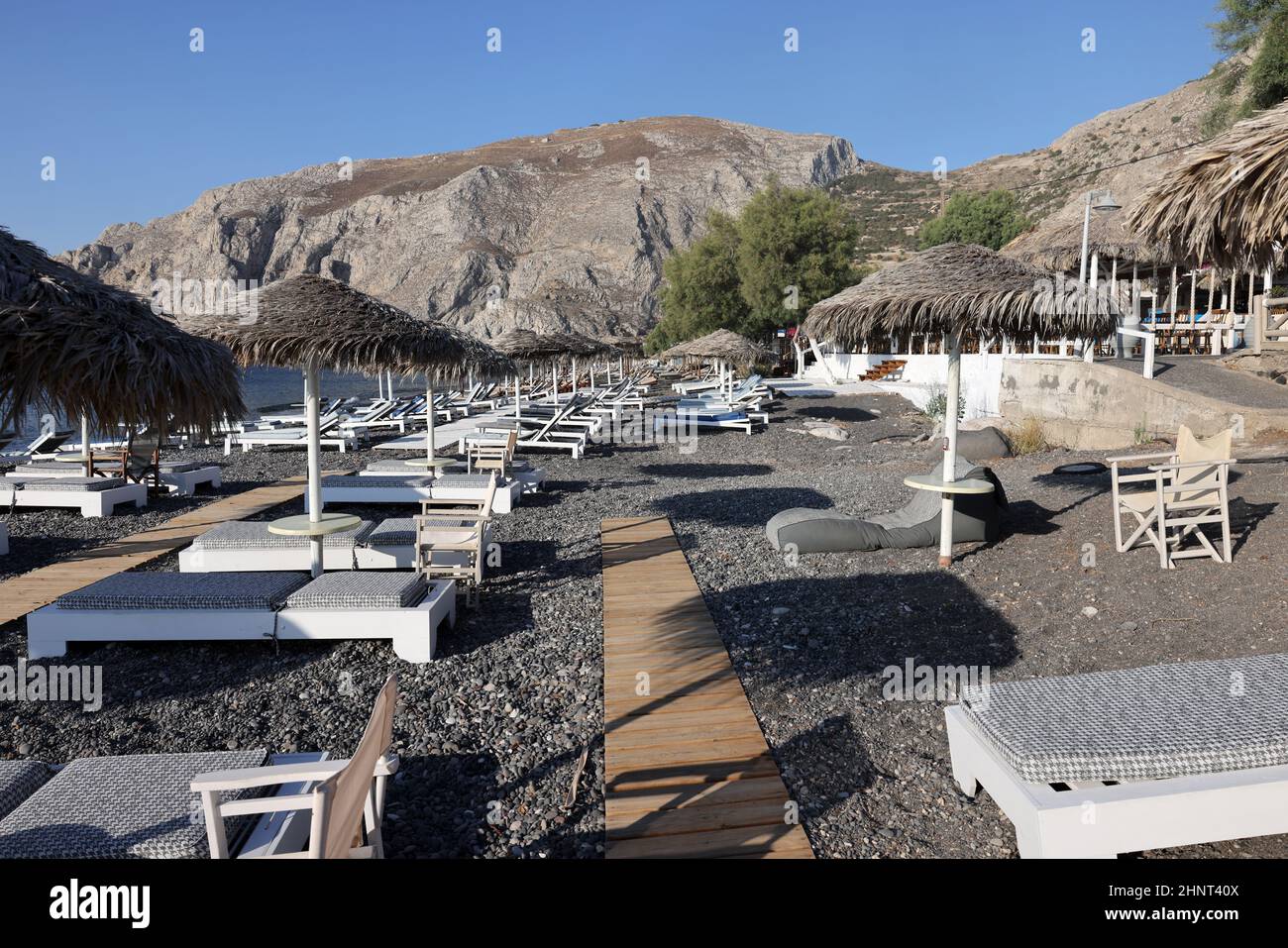 Sun loungers on the black volcanic beach of Kamari in Santorini. Cyclades, Greece Stock Photo