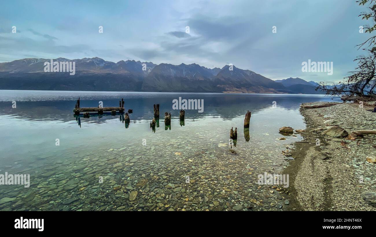 Ruined remains of an old wooden jetty on the shores of Lake Wakatipu near Glenorchy, Queenstown Stock Photo