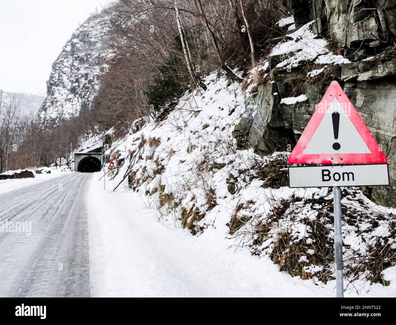Red road sign Bom and tunnel in Vik i Sogn, Vestland, Norway. Snow-covered landscape and roads. Stock Photo