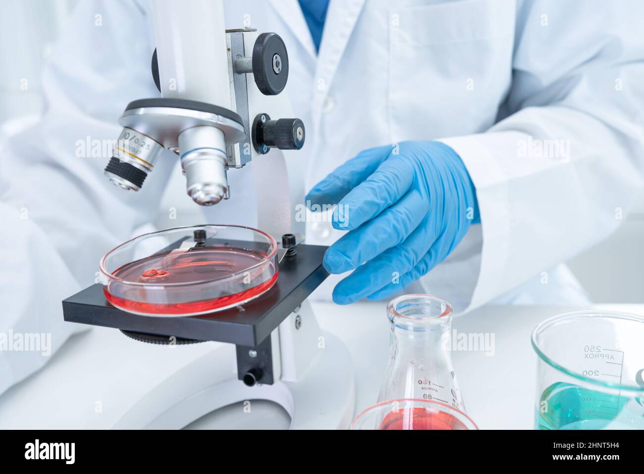 Asian scientist biochemist or microbiologist working research with a microscope in laboratory. For protect outbreak Coronavirus Covid19, bacteria and germs. Stock Photo