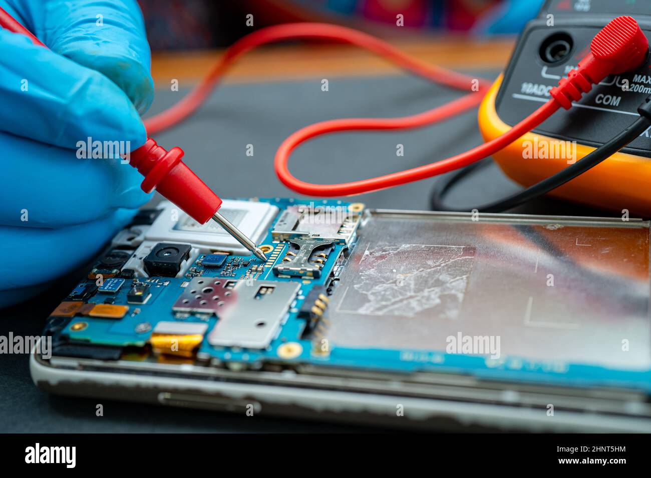 Technician repairing inside of mobile phone by soldering iron. Integrated Circuit. the concept of data, hardware, technology. Stock Photo