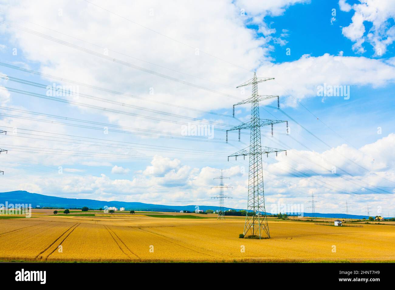 Electricity pylon in green field with blue sky with white hi-res stock ...
