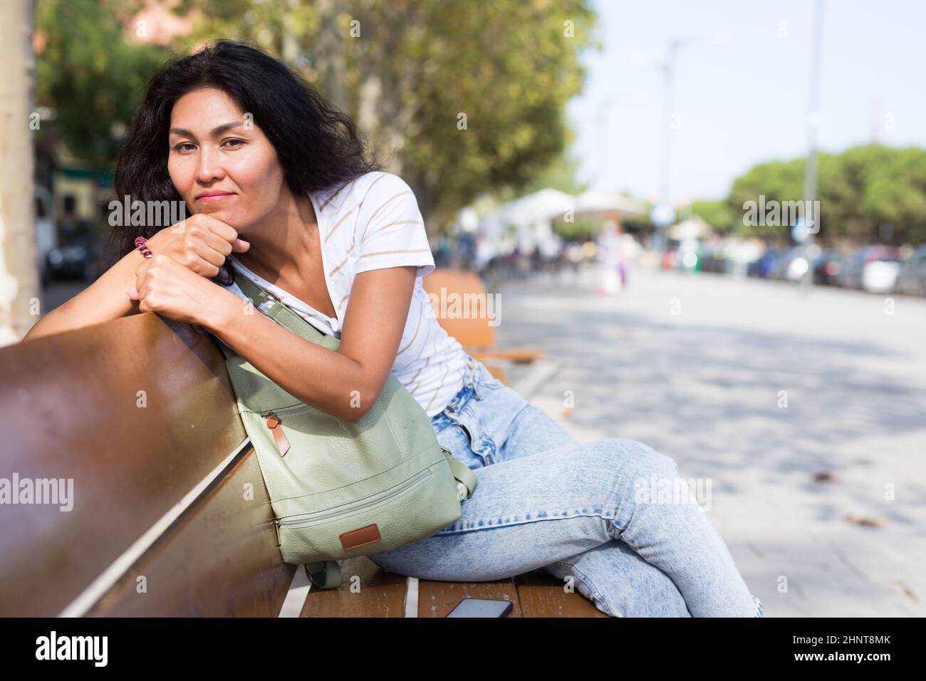 Woman sitting on bench n city park and resting Stock Photo - Alamy