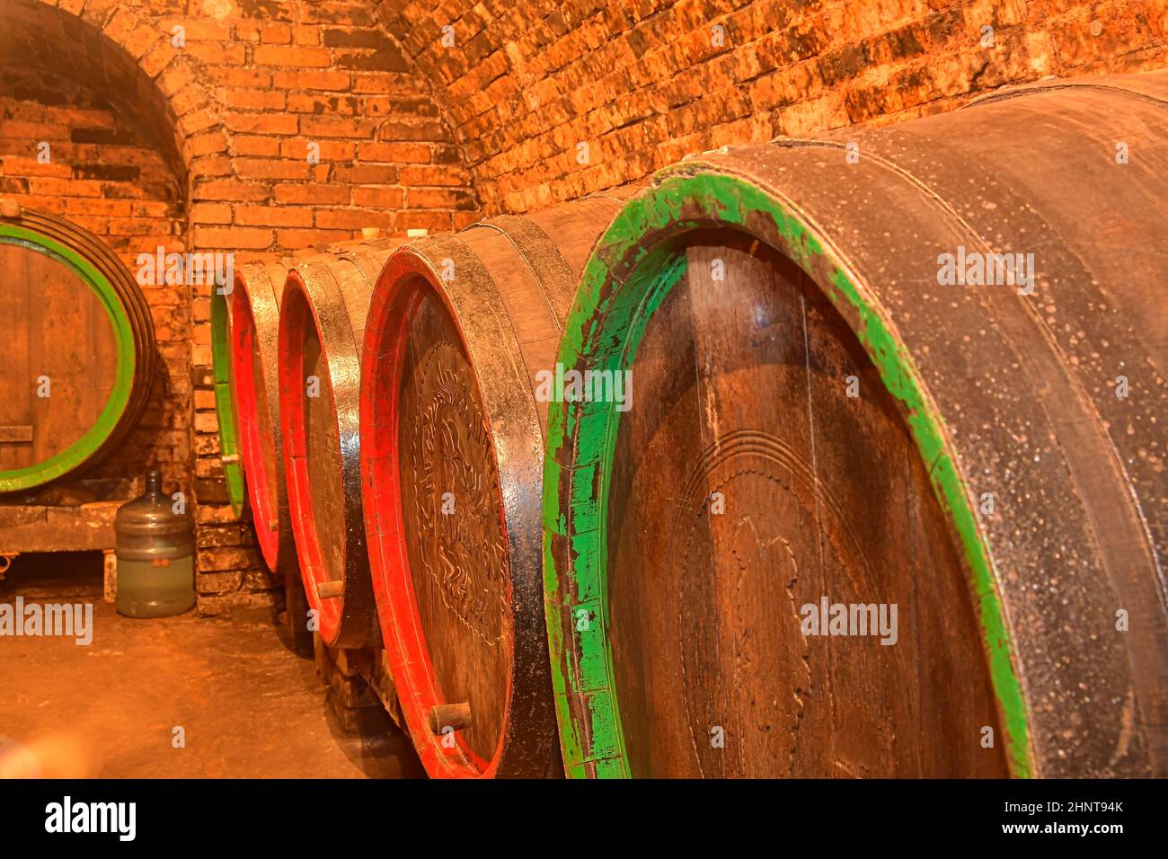 Old wooden barrels in the wine cellar. Wooden barrels with the wine at the cellar. Close-up Stock Photo
