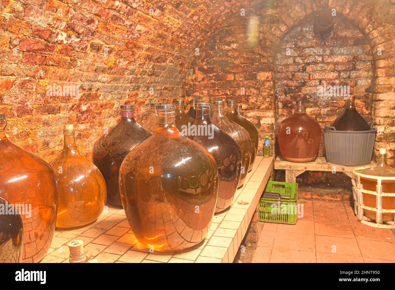 Vintage demijohns in a traditional wine cellar. Demijohn wine bottles Stock Photo