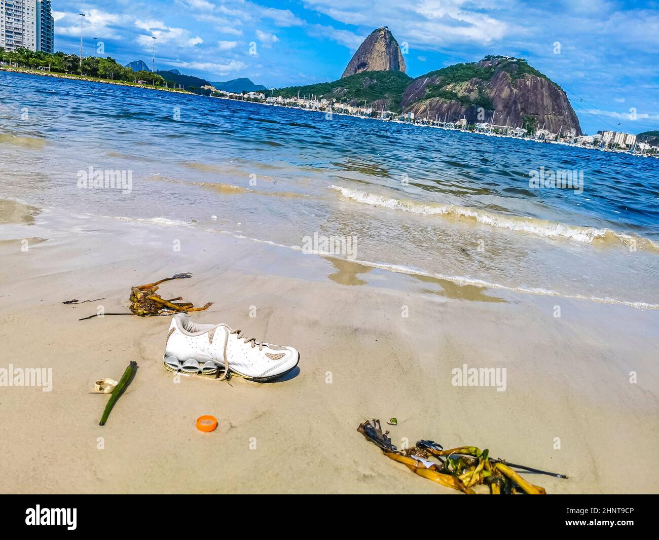 Shoes stranded washed up garbage pollution on beach Brazil. Stock Photo