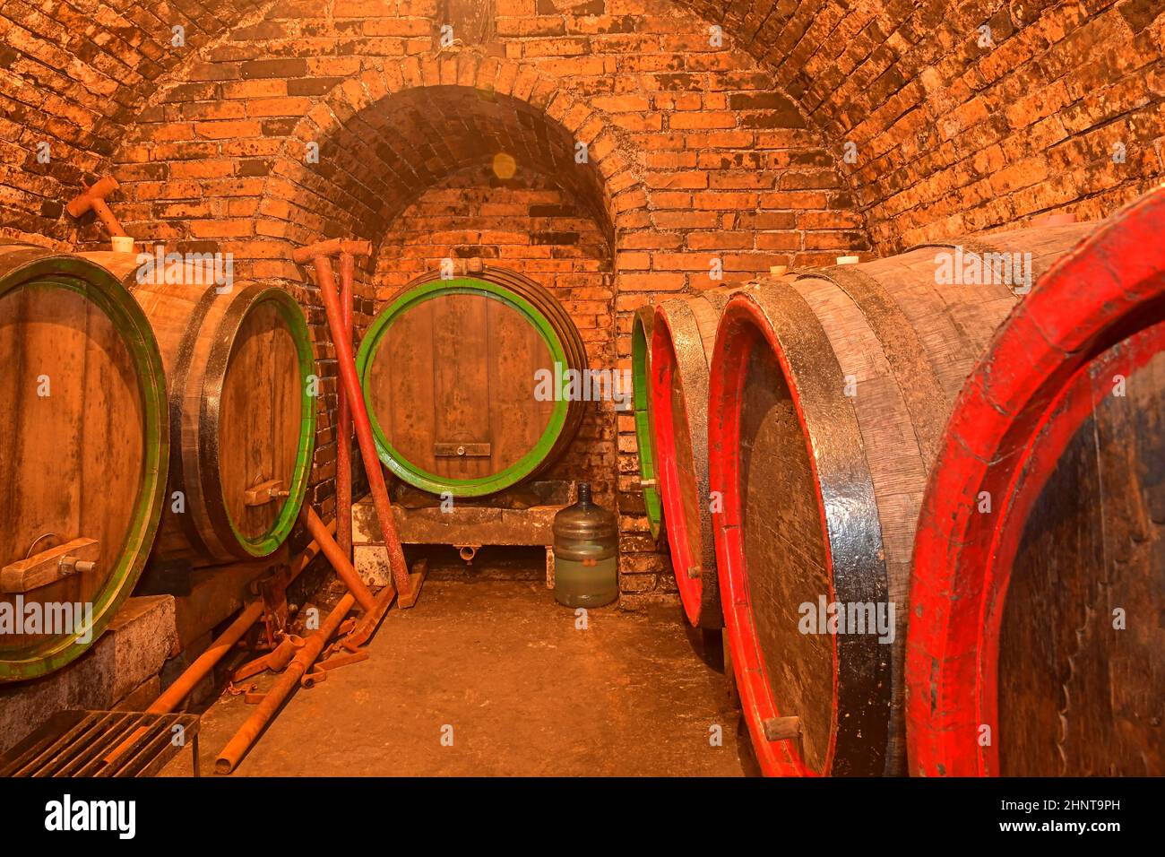 Barrels of wine in a wine cellar, an ancient wine cellar with vaulted brick ceilings. Traditional winemaking Stock Photo