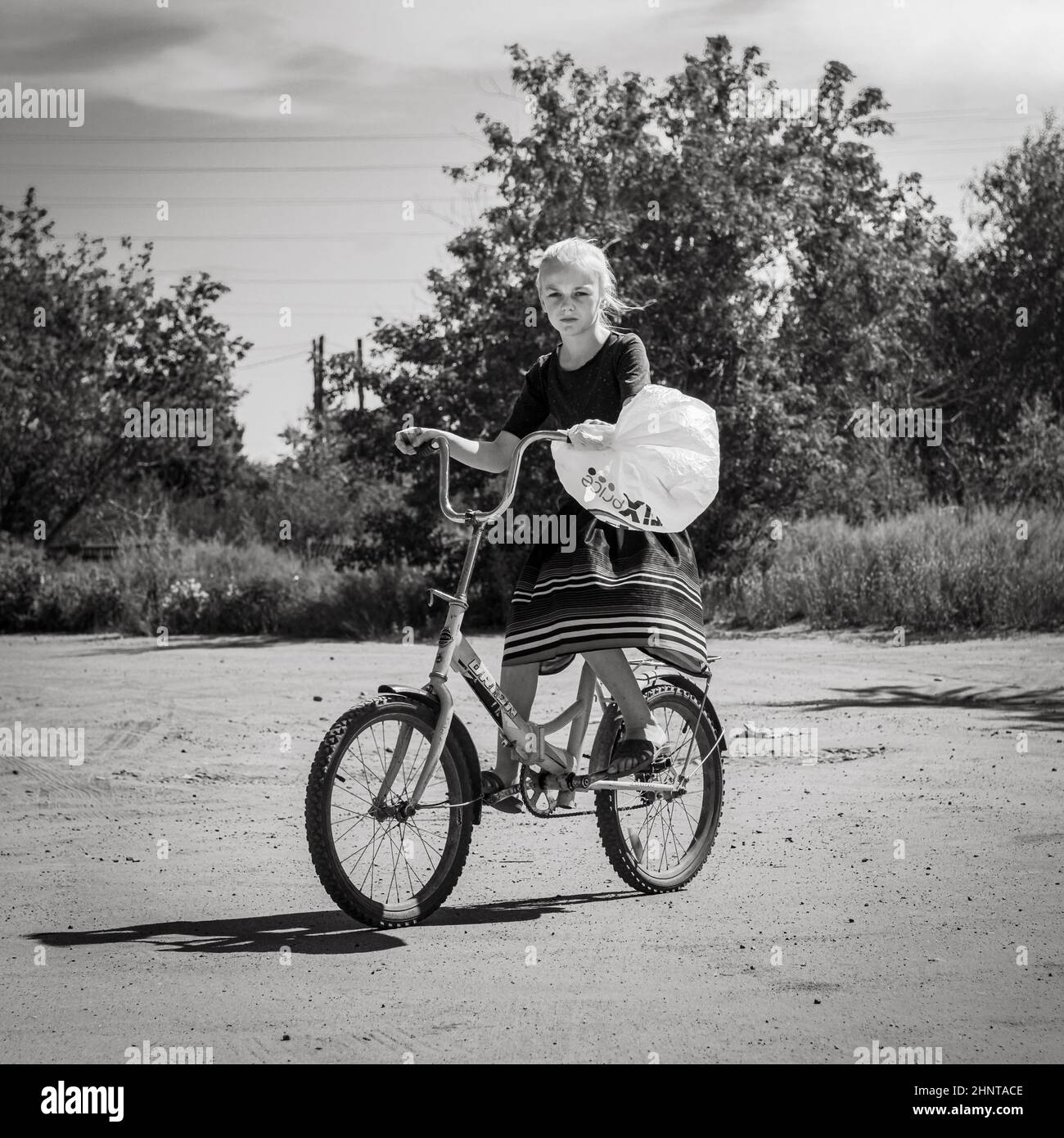 18th of July 2020, Russia, Altay,girl on a bike rural scene Stock Photo