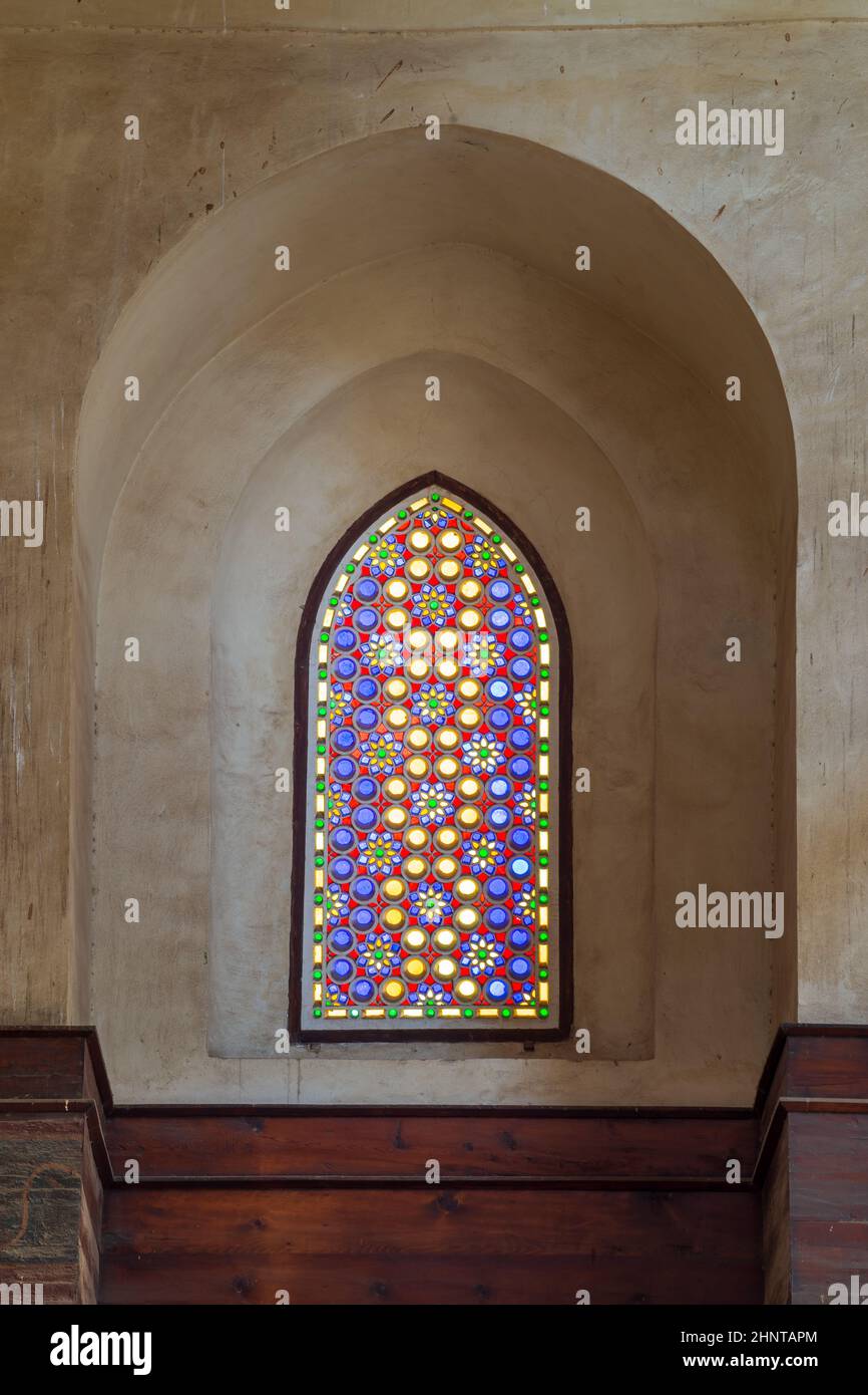 Mamluk era perforated stucco window with colorful stain glass with geometrical and floral patterns, Qalawun Complex Stock Photo