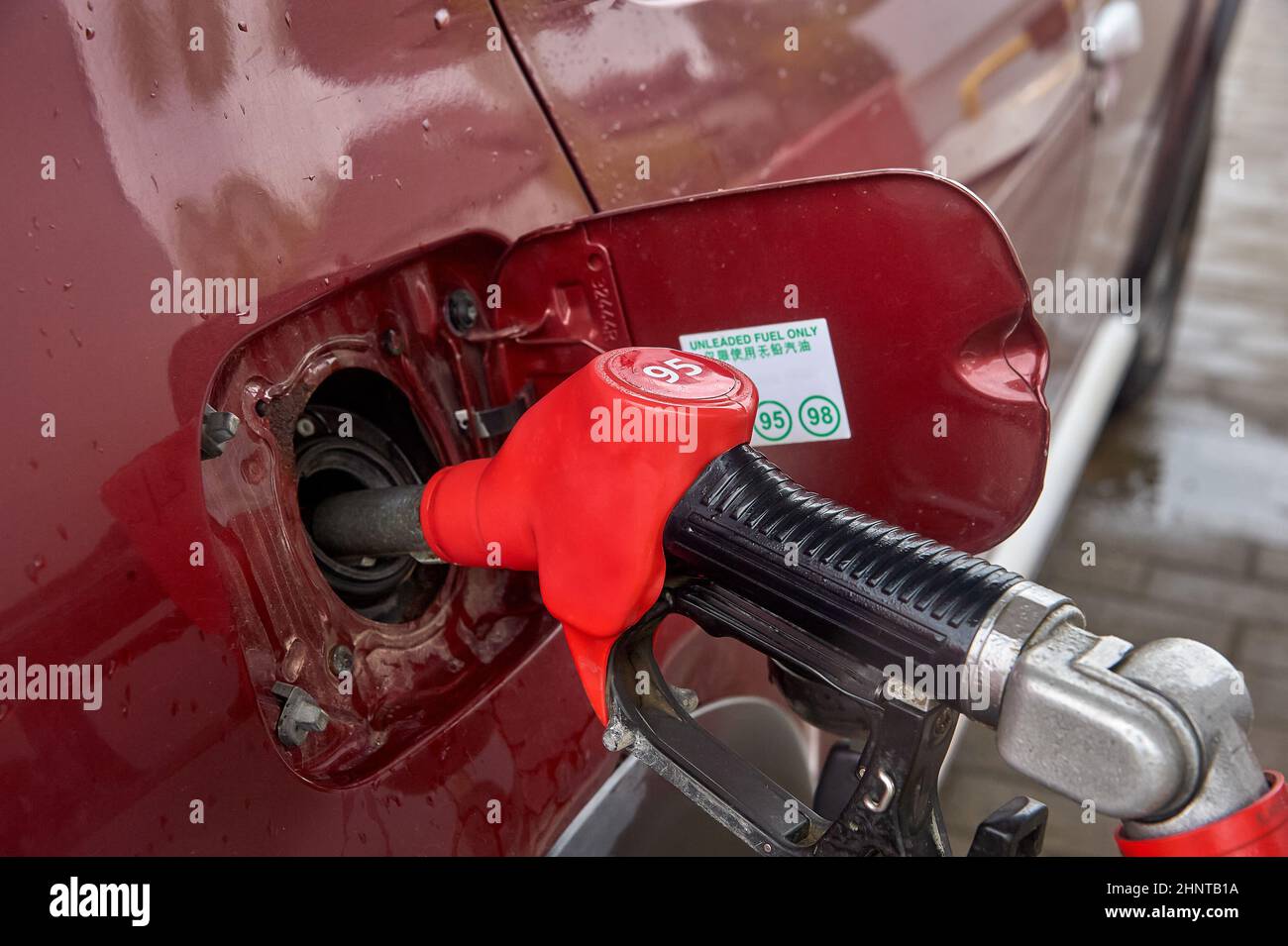the gun is inserted into the gas tank of the car Stock Photo