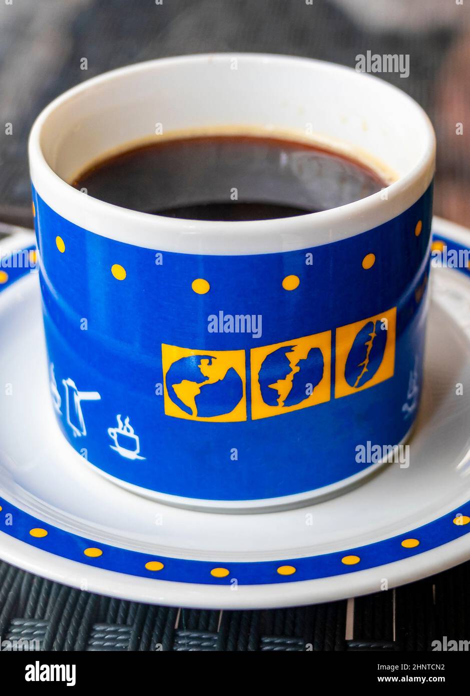 Black coffee in a blue cup with world globes, Thailand. Stock Photo