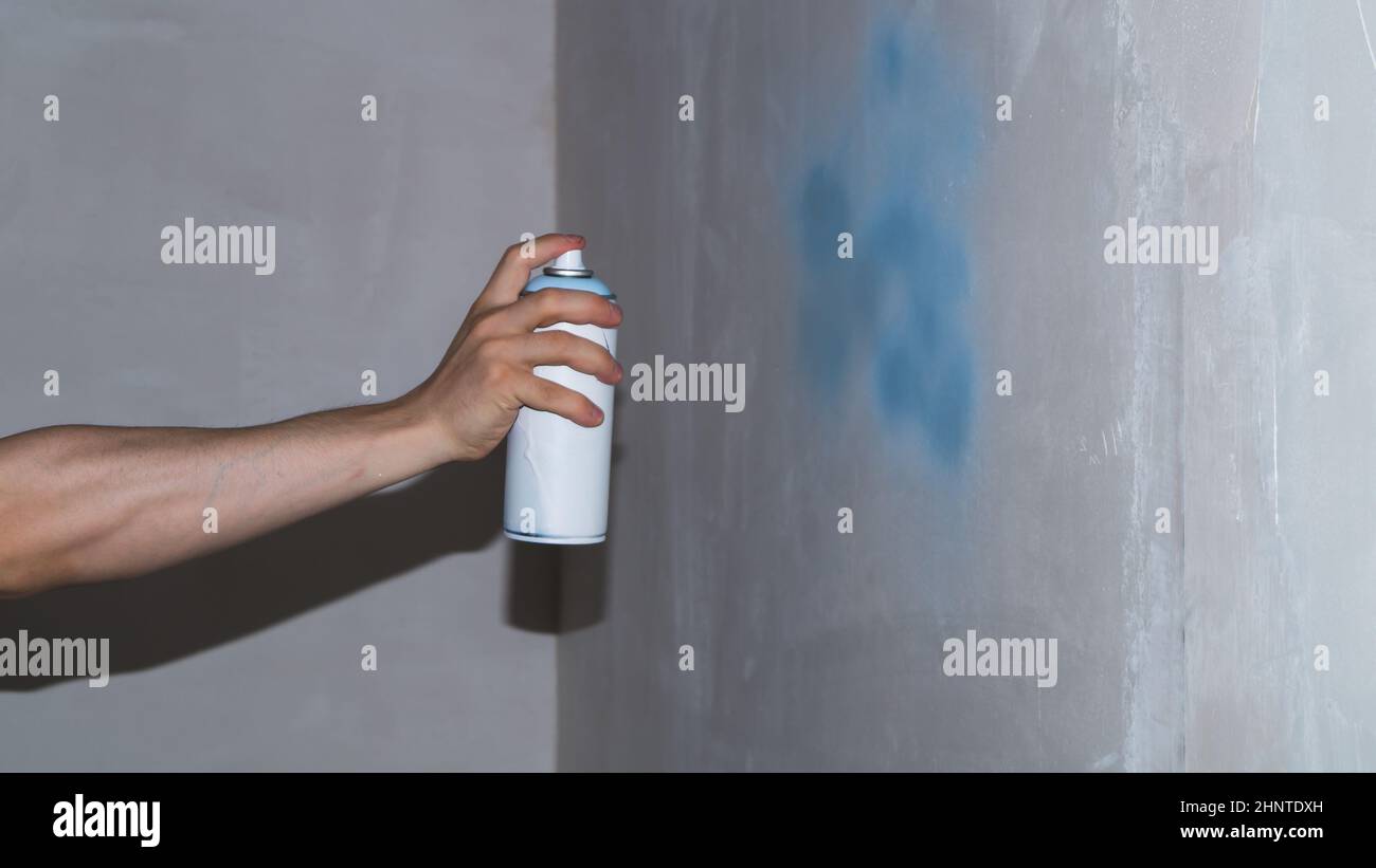 Spray can in the hand. spraying paint on the wall. painting process