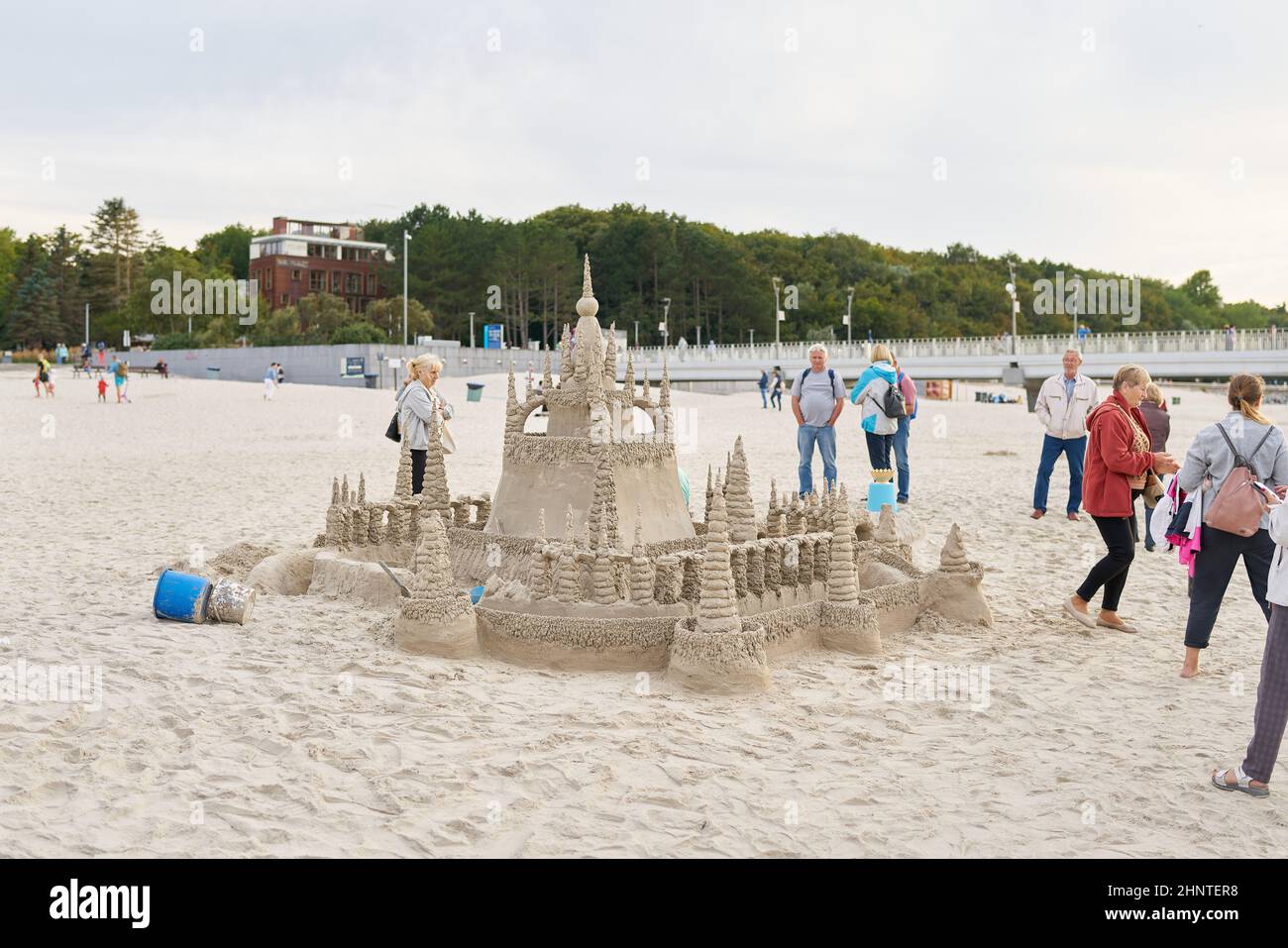 Holidaymakers admire a sandcastle on the beach of Kolobrzeg on the Polish coast of the Baltic Sea Stock Photo