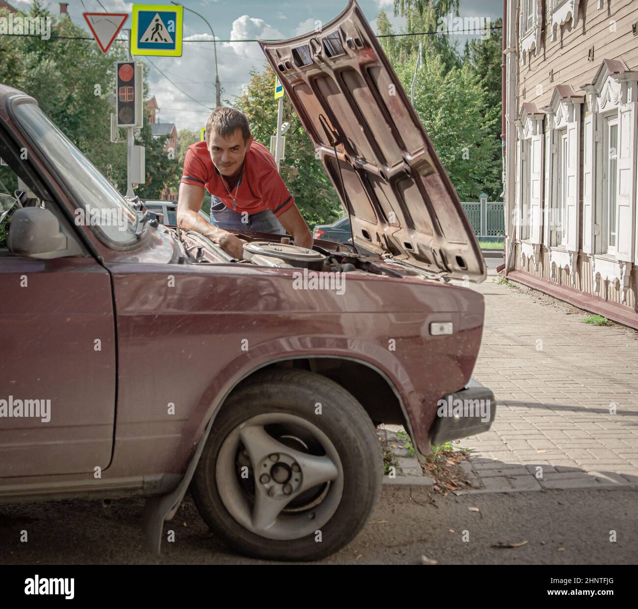 30th of August 2020, Russia, Tomsk, man repair a car at street Stock Photo