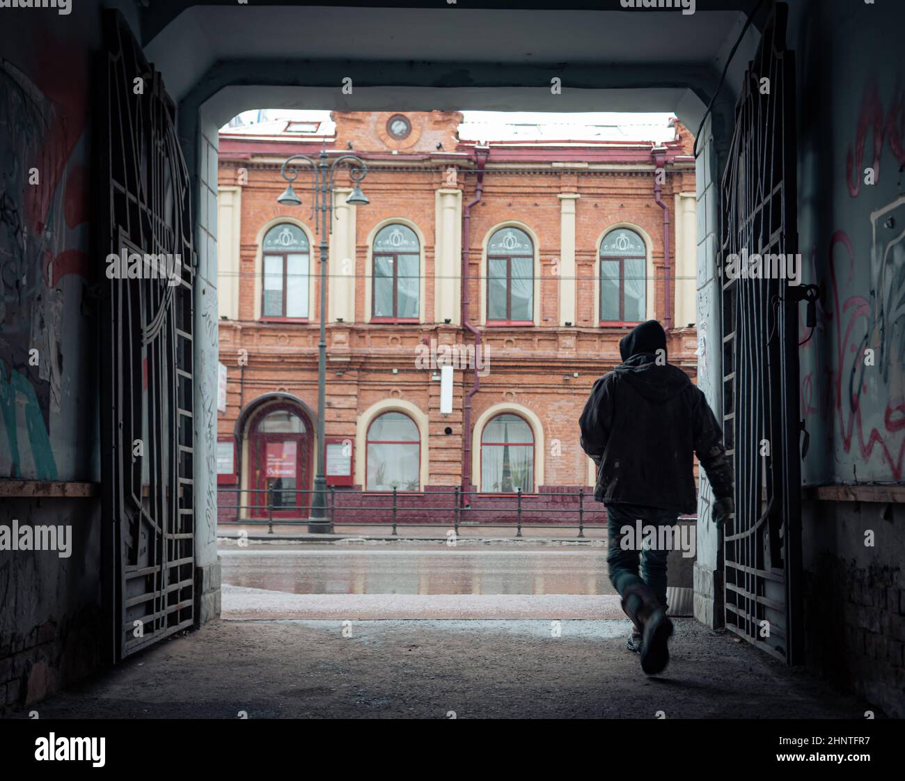 26th of October 2020, Russia, Tomsk, man go outside from arch to street Stock Photo